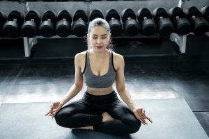Asian woman playing yoga in the gym.