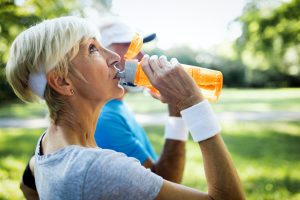 Mature couple drinks water to replenish energy and to hydrate